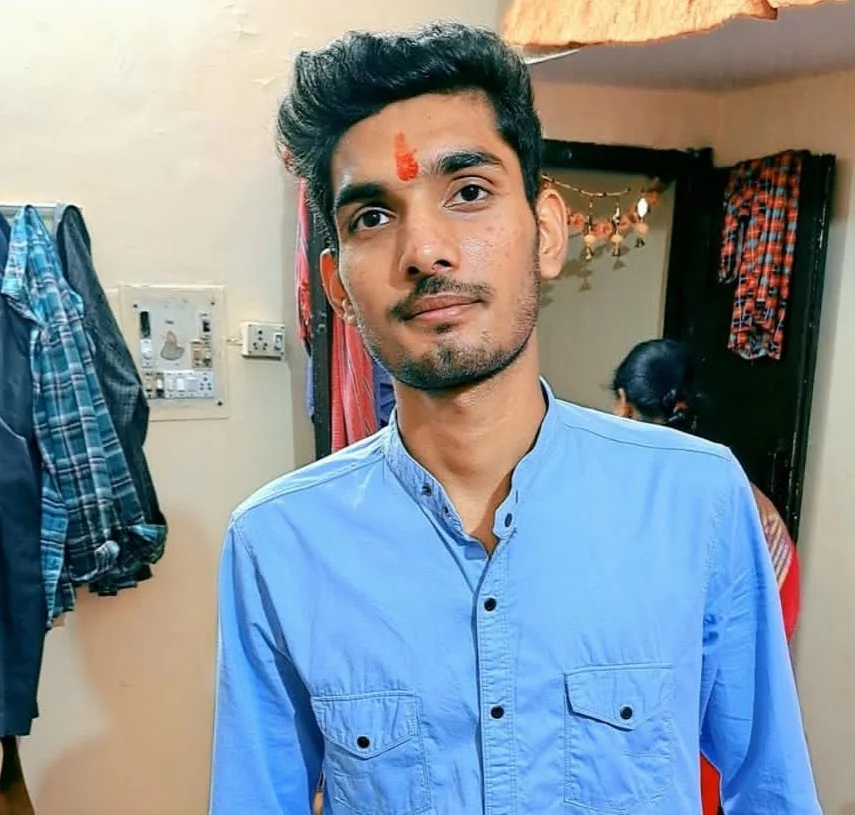 A man wearing a blue shirt posing for a photo.